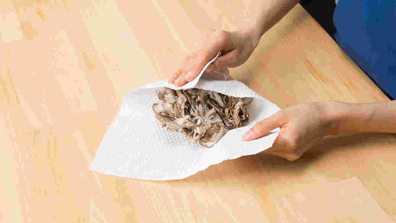 キッチンペーパーで舞茸を拭いている様子