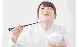 白米を美味しそうに食べている女性