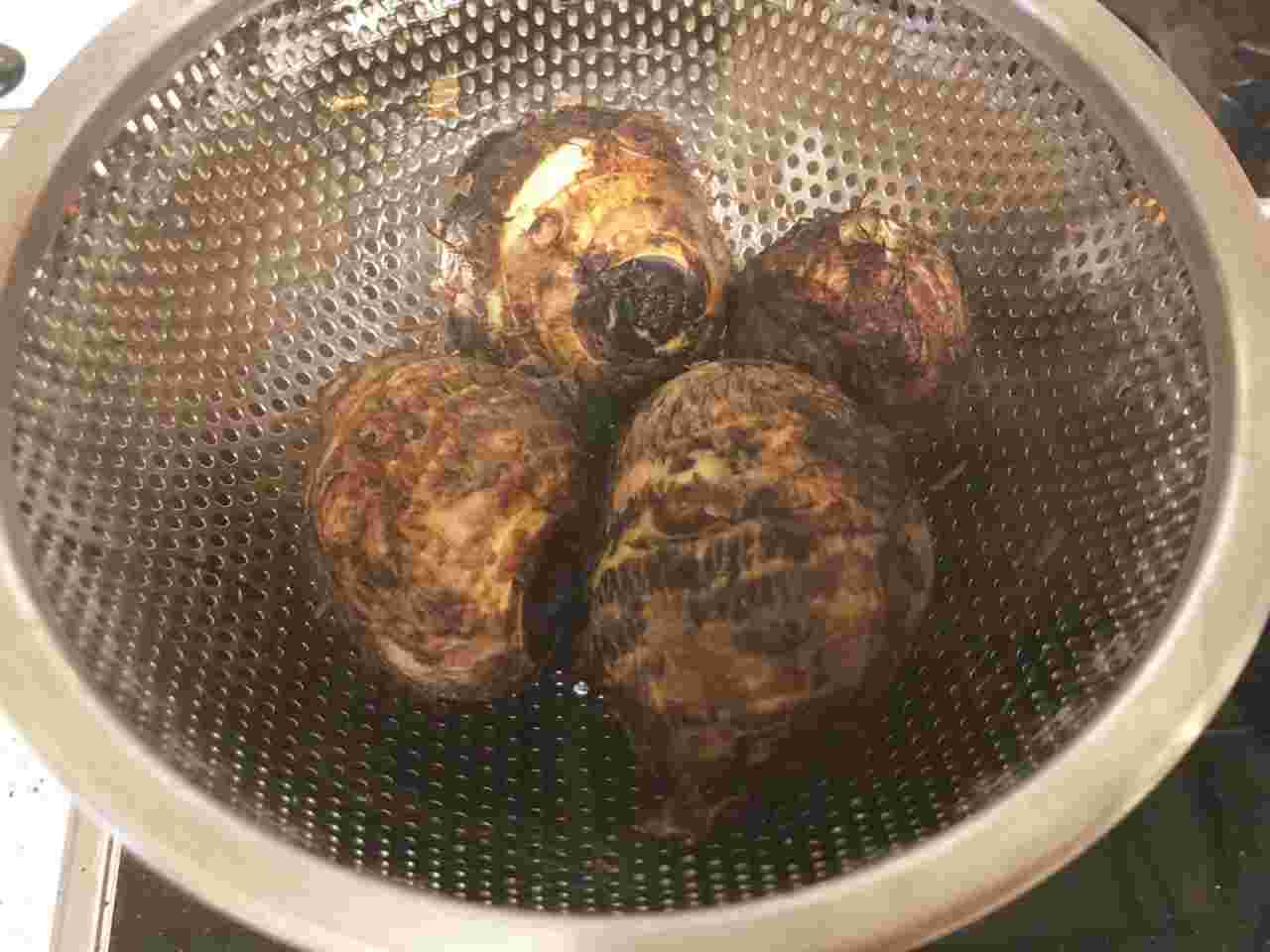 ザルにとった里芋を冷水で冷やしている