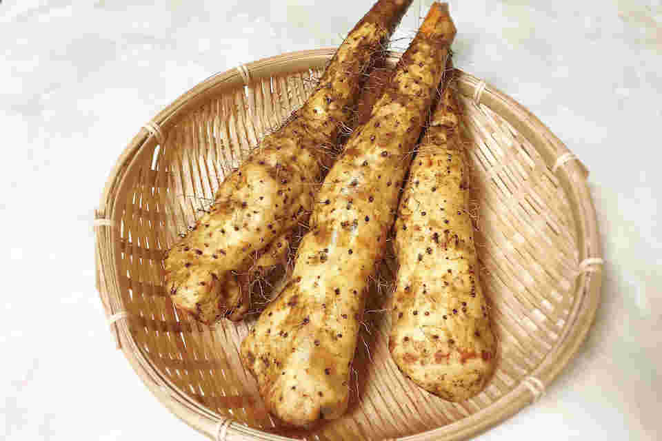丸い竹ザルの上に3本の大和イモが綺麗に並べられている