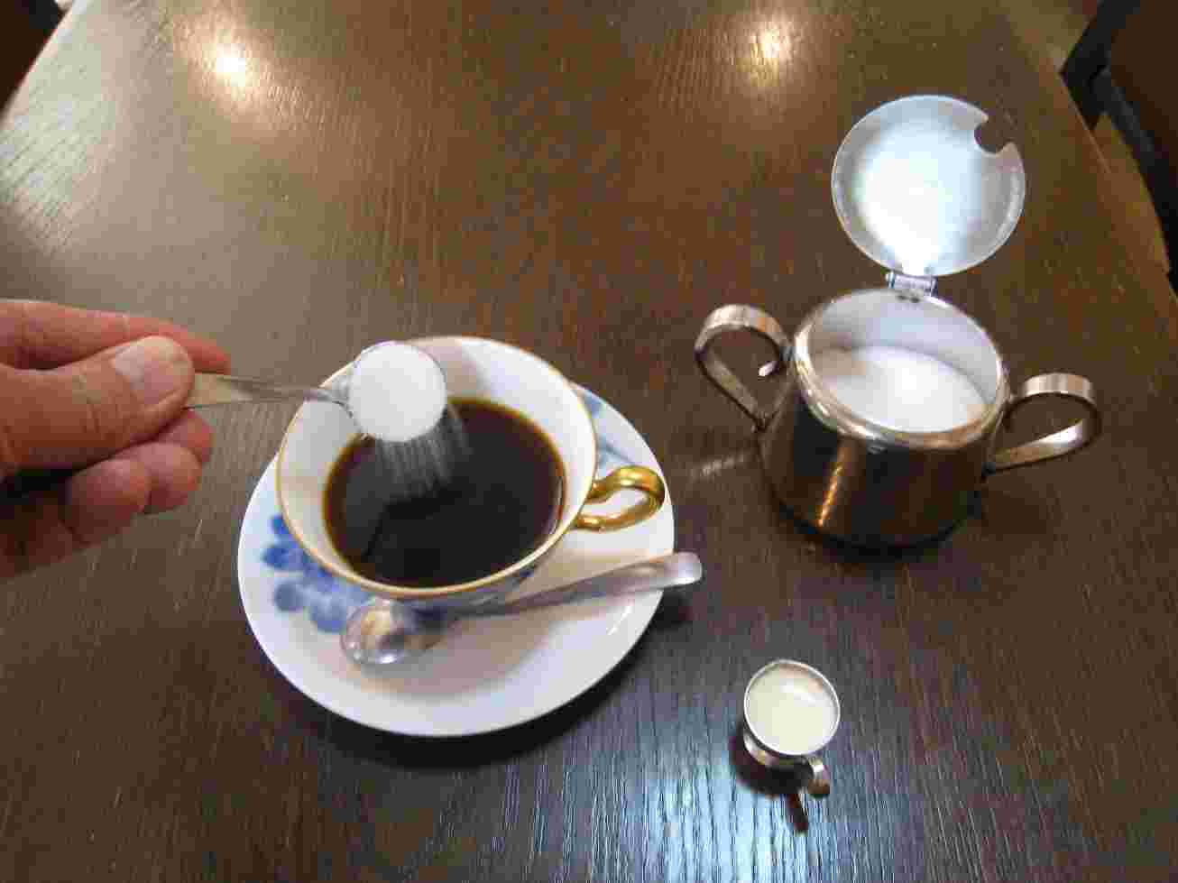 コーヒーに砂糖とミルクを入れているところ