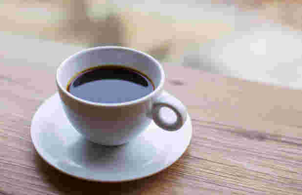 テーブルの上に置かれた白いカップに入っているコーヒー