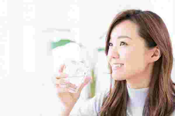 水を飲んで笑顔の女性