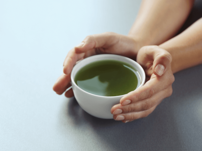緑茶の入った器に手を当てる