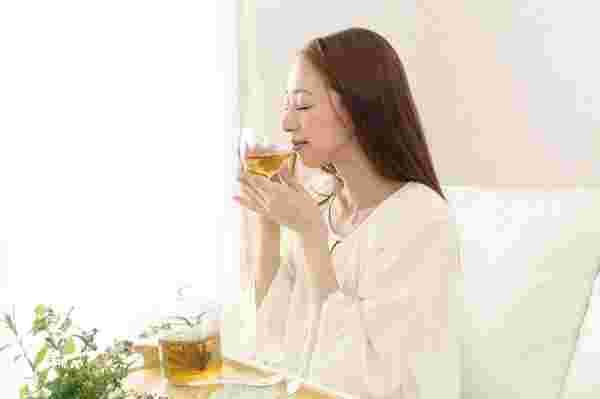 ハーブティーを飲んで癒される女性