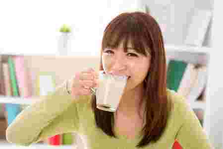 豆乳を飲みながら笑顔の女性