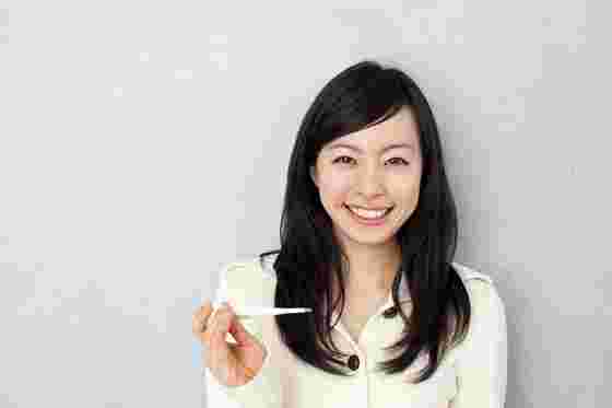 体温を計測する笑顔の女性