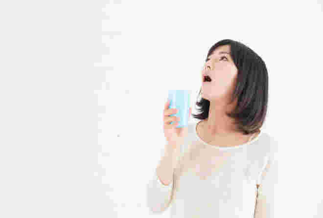 カップを持ってうがいする女性