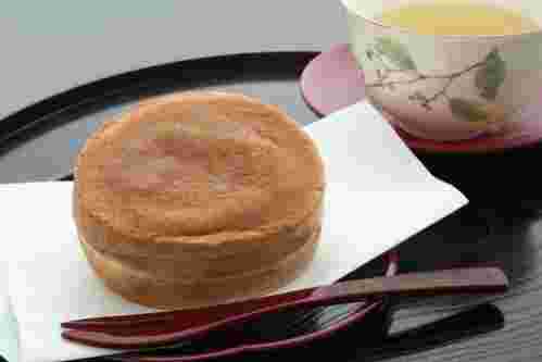 お盆にお茶と一緒に大判焼きがのせられて楊枝が添えられている