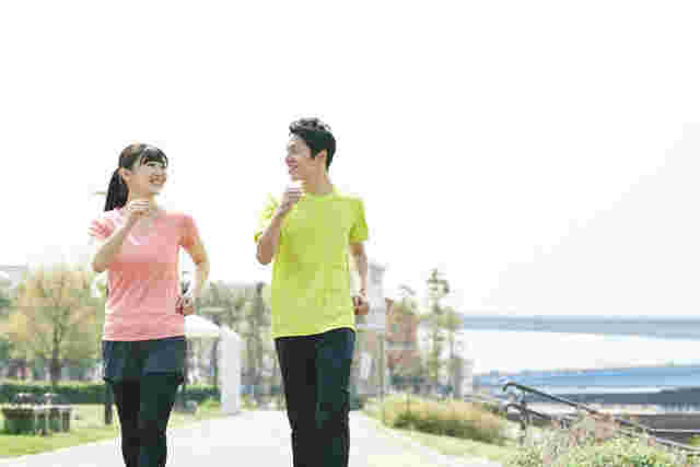 景色の良い道で男女がウォーキングをしている様子