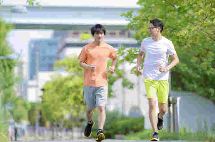 景色の良い外で2人の男性がランニングをしている