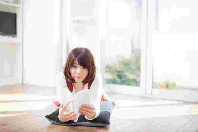 寝そべって読書をしている女性