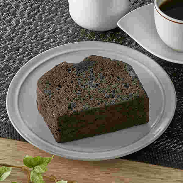 丸いお皿の中に形が四角で分厚いチョコケーキが美味しそう