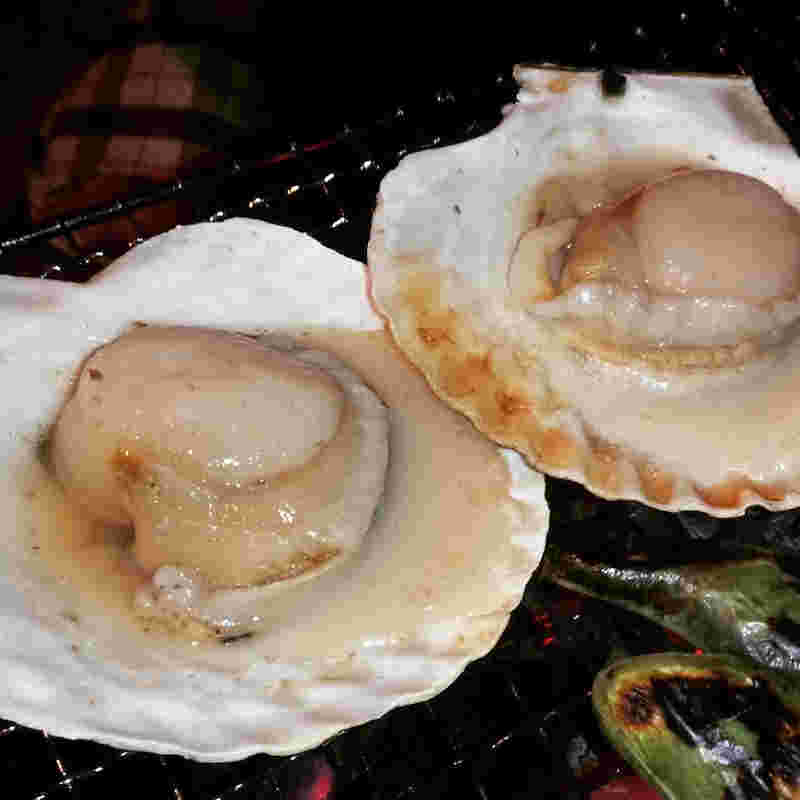 七輪の上で焼かれた殻付きホタテ