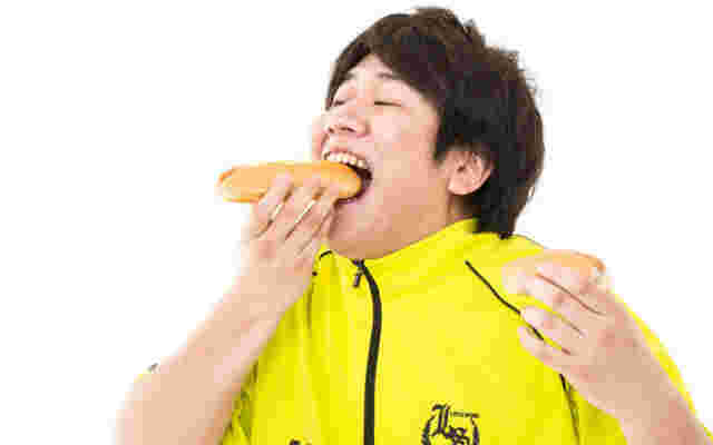 男性がパンを食べている画像