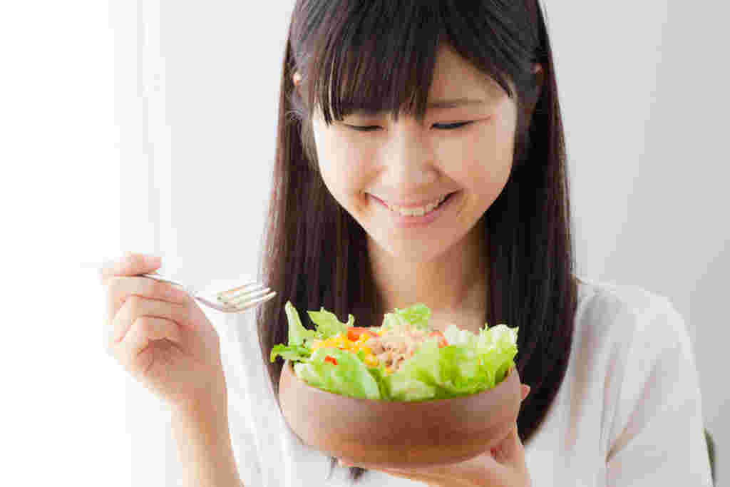 サラダを目の前に笑顔の女性