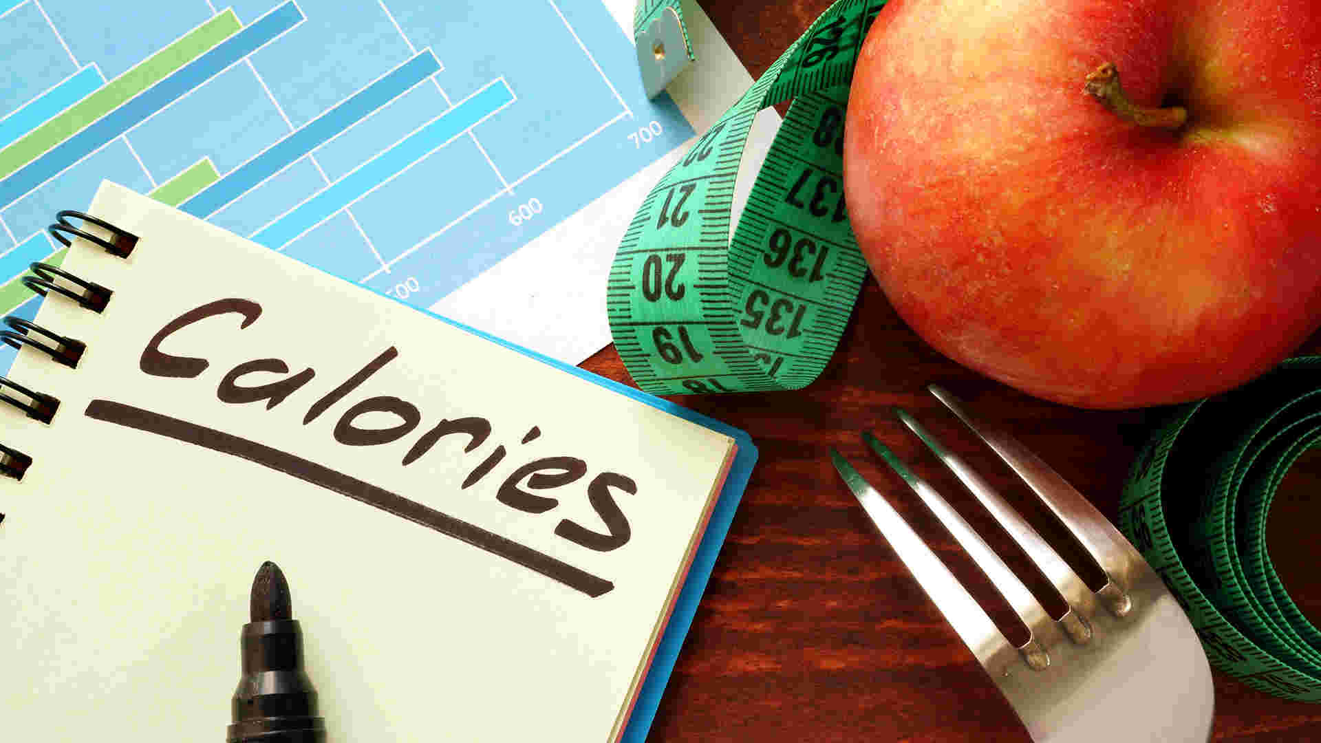メジャーとCaloriesと書かれたノート