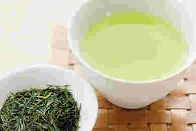 湯吞みに入った緑茶と緑茶の茶葉