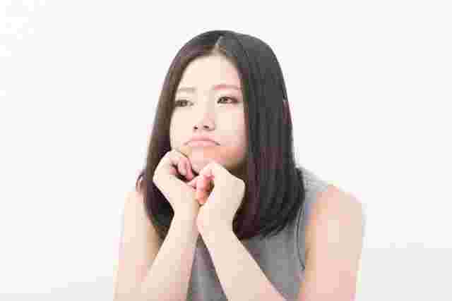 頬杖をつき機嫌が悪そうな女性