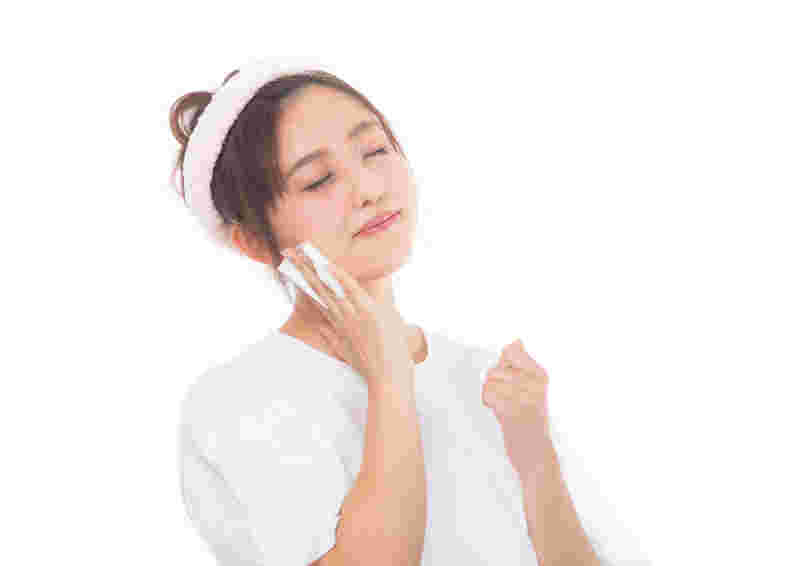 コットンを顔にあてている女性