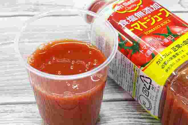 ペットボトルのトマトジュースと透明なカップにトマトジュース