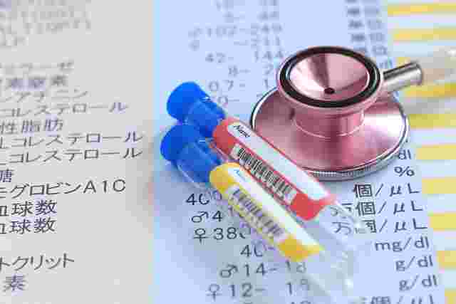聴診器と採血用の容器と血液検査結果の用紙