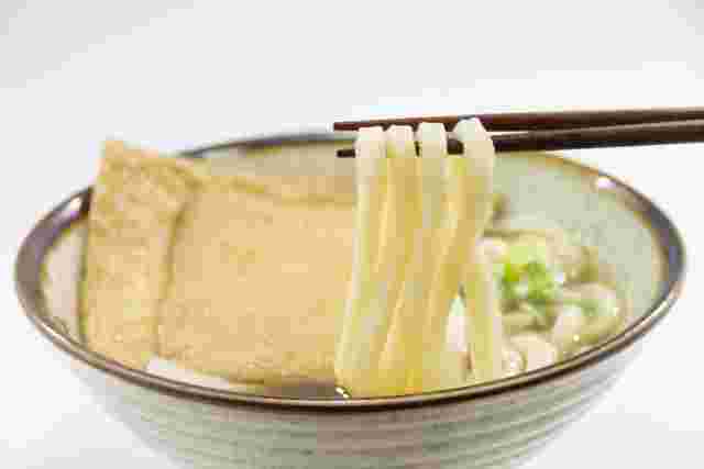 きつねうどんの麺を箸で持ち上げる