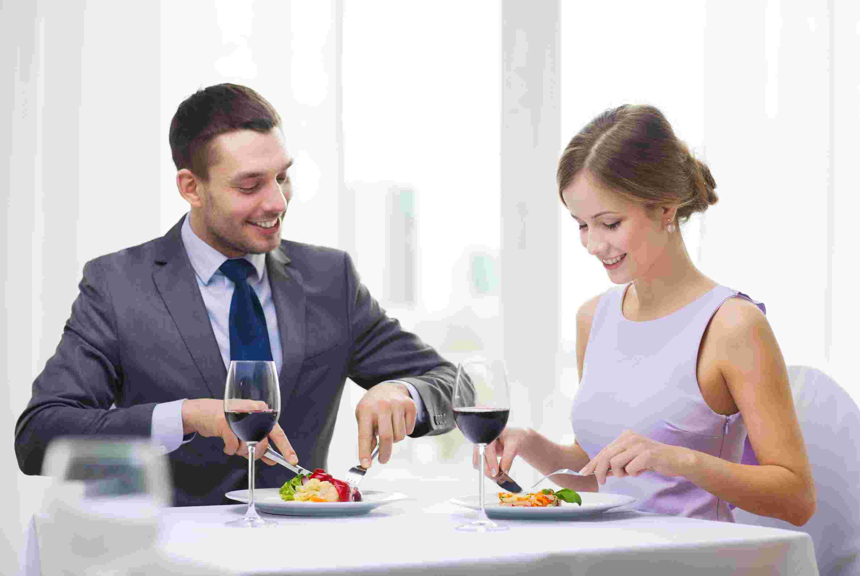 ワインを飲みながら食事する男女
