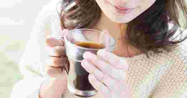 温かい飲み物を飲んでい冷えを改善している女性