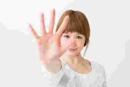 手のひらを前に差し出す女性