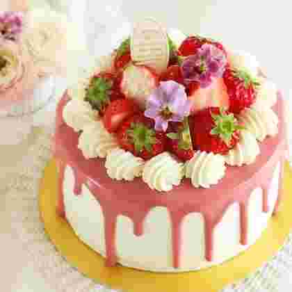 ピンクのグラサージュをかけていちごや花を乗せて鮮やかなドリップケーキ