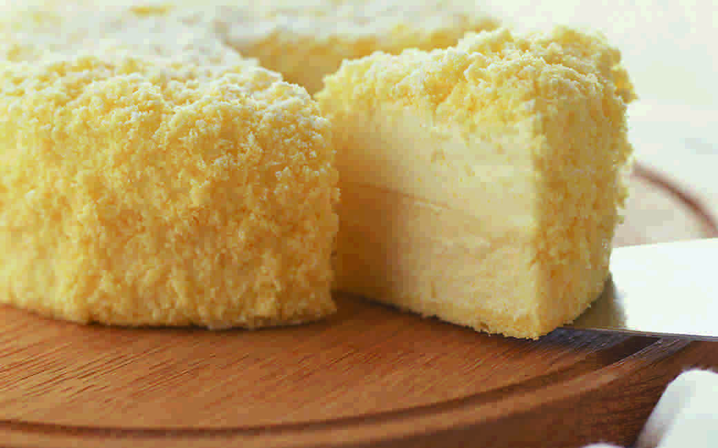 ホールのチーズケーキをカットしている画像