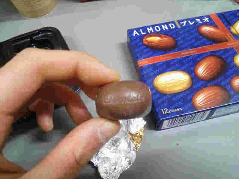 アーモンドチョコを手に持っている