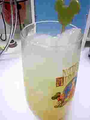 小さめのグラスに氷が入ったお酒にマドーラが入れられている