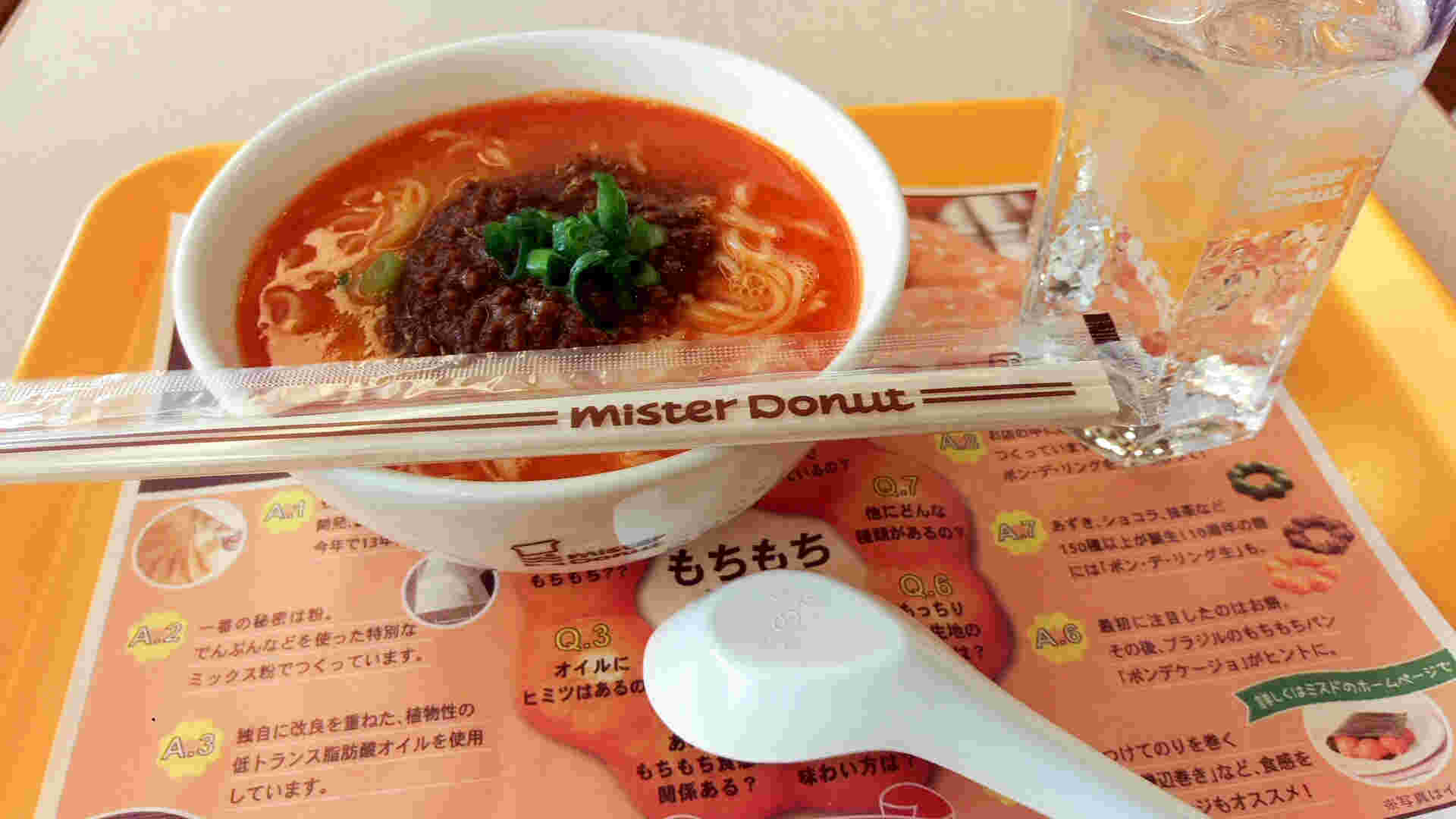 オレンジのトレイに担々麺と水とれんげ