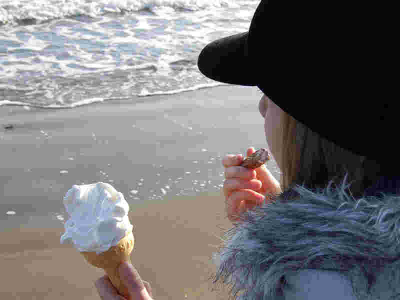 コーンのアイスクリームを食べる女性