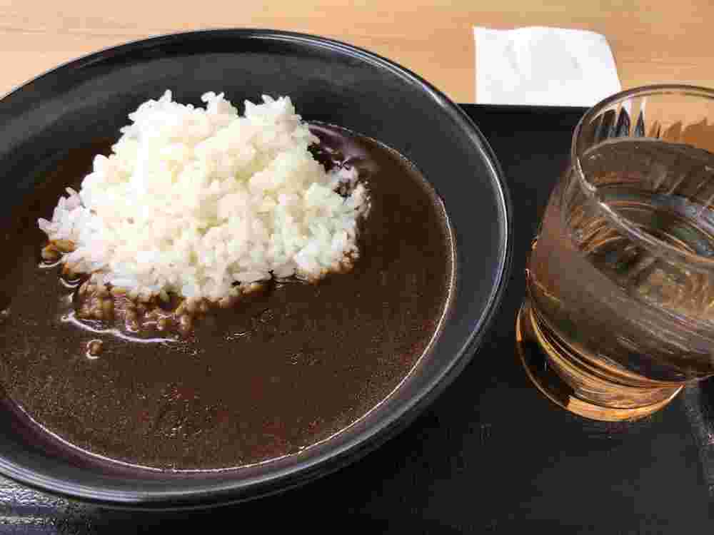 吉野家の黒カレーとコップに入ったお水