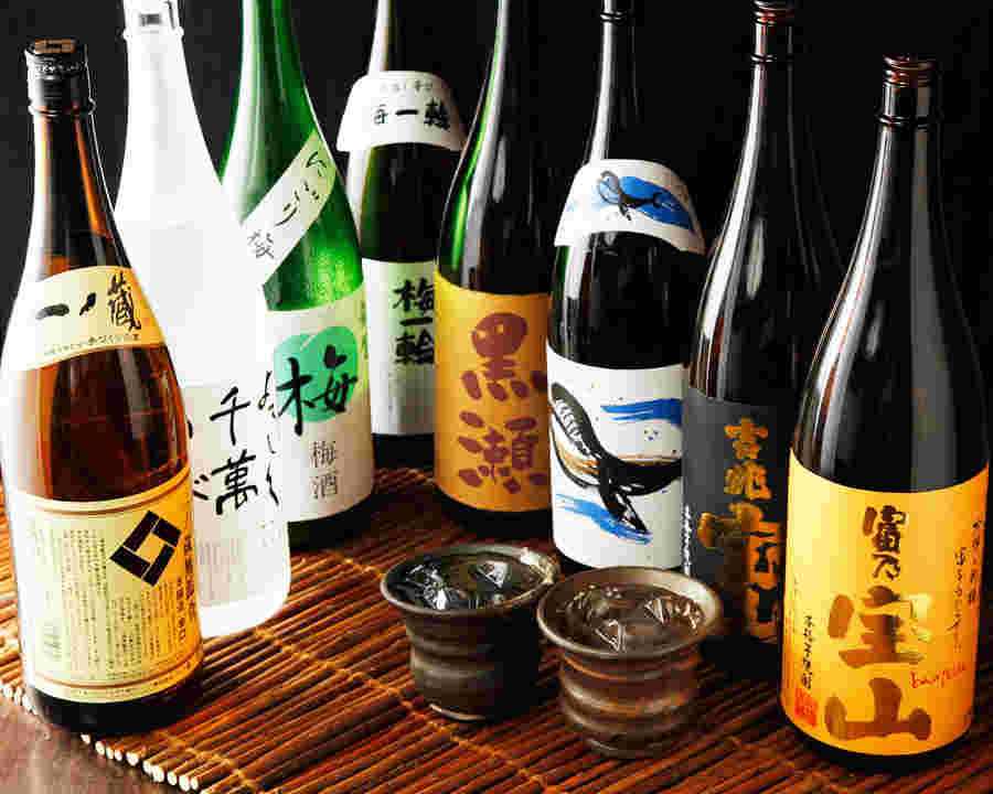 焼酎のボトルの数々とコップに注がれた焼酎