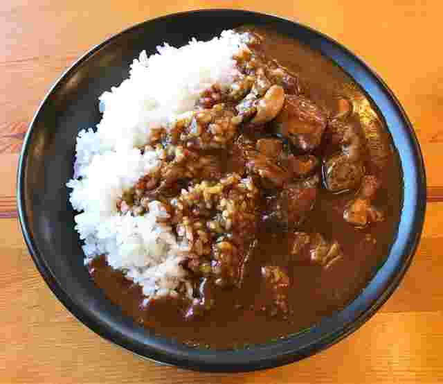 丸い大きめの皿に白ご飯と濃ゆめのカレーのルーがたっぷりと入って美味しそう