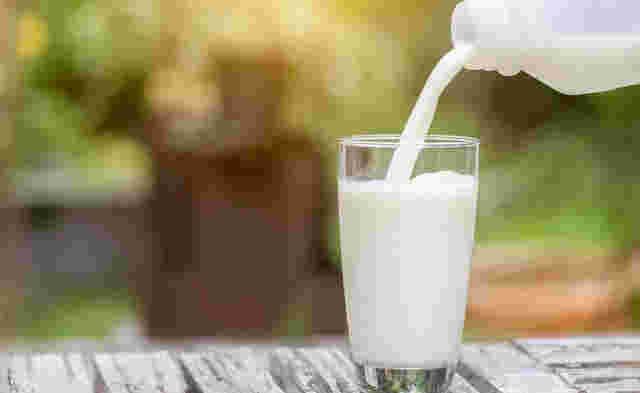 コップに牛乳を注いでいるところ