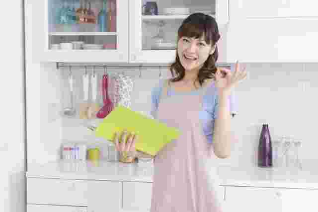 キッチンでオッケーサインをする女性