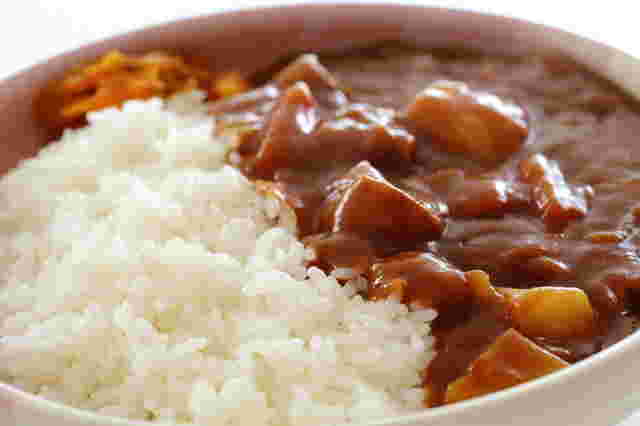 丸みのある皿に白米半分、カレーのルー半分が盛り付けられている