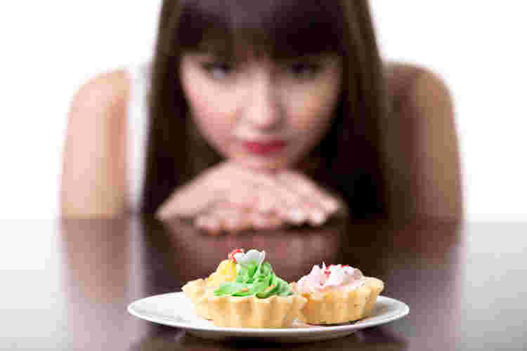 女性がカップケーキを見つめる