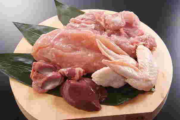 お盆に乗った様々な部位の鶏肉（レバー、手羽先、もも肉、むね肉など）