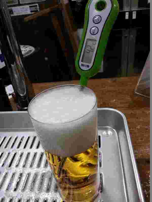 ビールに温度計を指して測っている