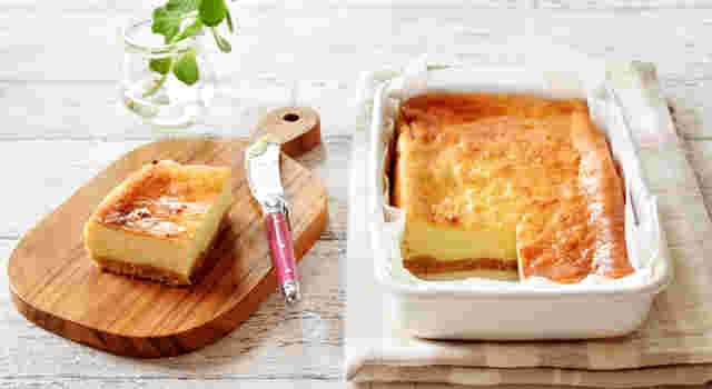 器に入った豆腐チーズケーキと木のプレートに一切れのチーズケーキとバターナイフ