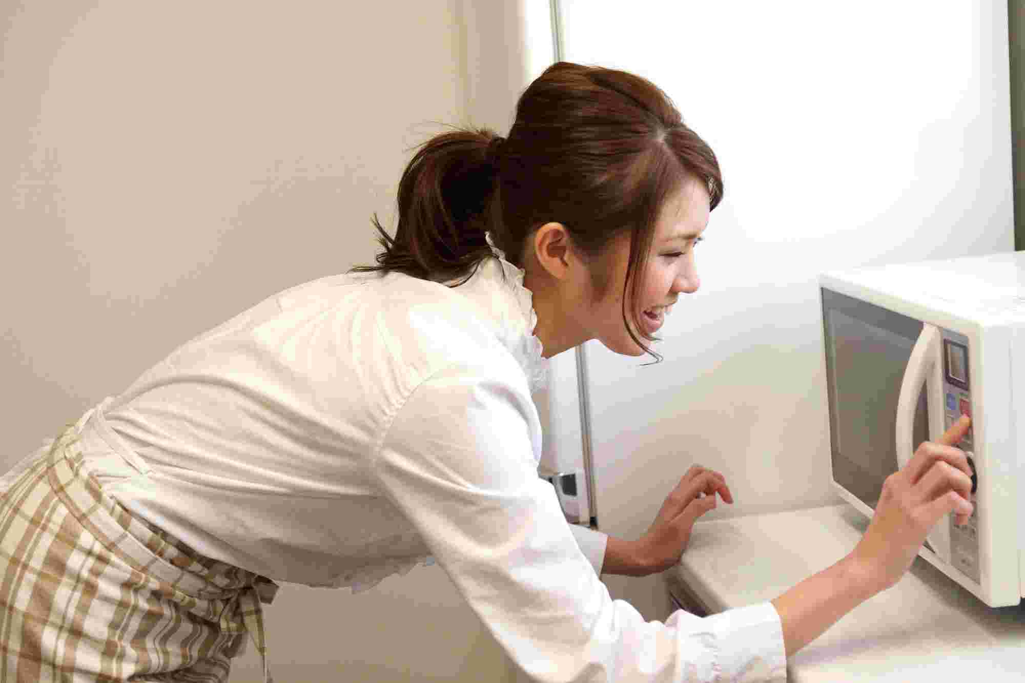 電子レンジを操作している女性