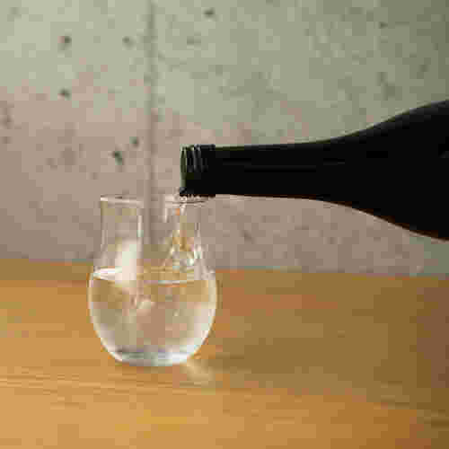 焼酎をグラスに注いでいる様子