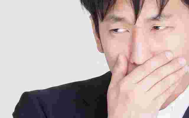 口元をおさえる男性
