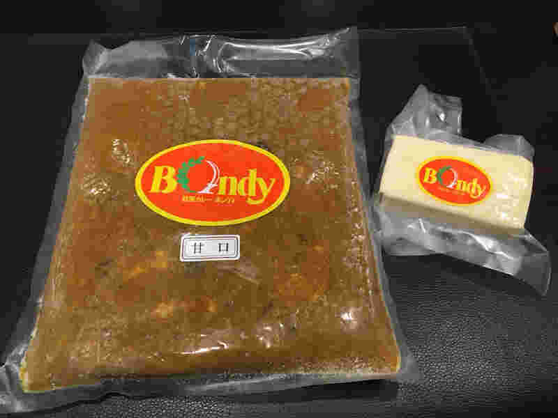大きめの真空パックに入れられた冷凍カレールーと小さめの真空パックに入れられた冷凍チーズ